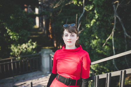 young beautiful red dressed vintage hipster woman in street townの写真素材