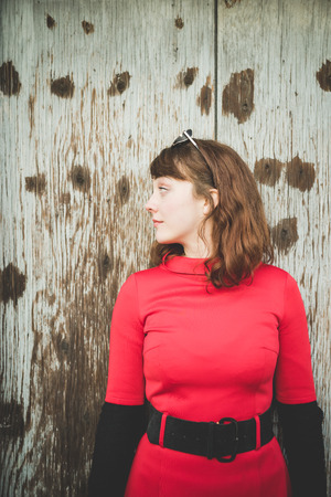 young beautiful red dressed vintage hipster woman in street townの写真素材