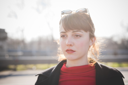 young beautiful red dressed vintage hipster woman in street townの写真素材