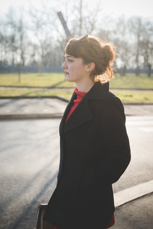 young beautiful red dressed vintage hipster woman in street townの写真素材