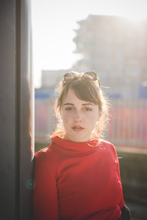 young beautiful red dressed vintage hipster woman in street townの写真素材
