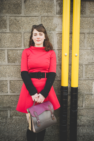 young beautiful red dressed vintage hipster woman in street townの写真素材