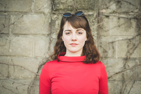 young beautiful red dressed vintage hipster woman in street townの写真素材