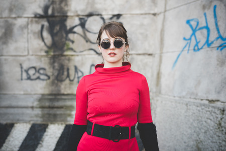 young beautiful red dressed vintage hipster woman in street townの写真素材