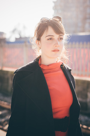 young beautiful red dressed vintage hipster woman in street townの写真素材
