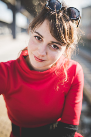 young beautiful red dressed vintage hipster woman in street townの写真素材