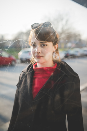 young beautiful red dressed vintage hipster woman in street townの写真素材