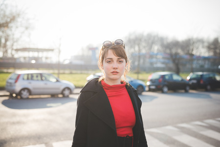 young beautiful red dressed vintage hipster woman in street townの写真素材