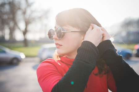 young beautiful red dressed vintage hipster woman in street townの写真素材