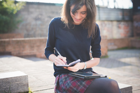 young pretty woman in town using tablet multitasking