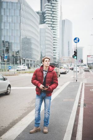 Young handsome caucasian contemporary businessman walking through the city using a tablet...