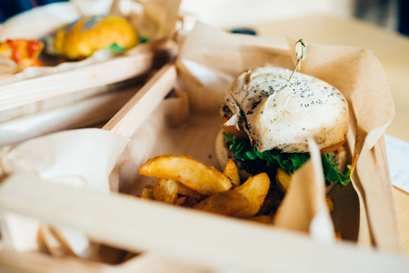 Close up on a veggie hamburger served in a basket with potato chips and ketchup - healthy, lifestyle, food conceptの写真素材