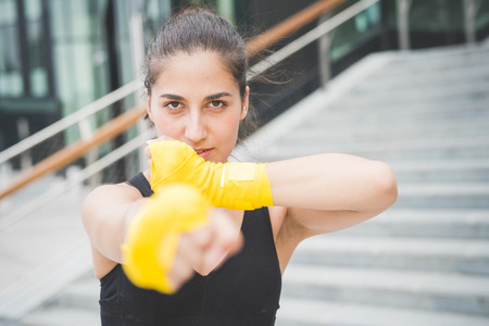 Half length of a young handsome caucasian brown hair boxer woman boxing, looking in camera - sportive, training, healthy, fitness conceptの写真素材