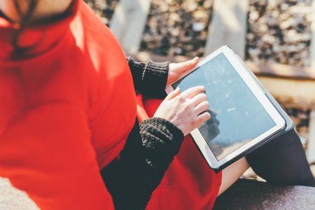Rear view close up of young beautiful woman holding a tablet, tapping the screen - technology, social network, communication conceptの写真素材