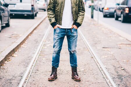 From the neck down view of young fashionable man outdoor in the city with his hands in his pocketの写真素材