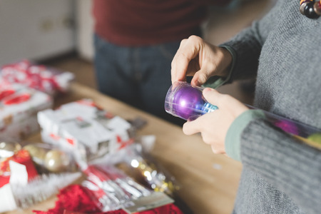 Close up on the hand of woman assembling christmas tree, unpacking decoration, looking downward,  - christmas, holiday, winter conceptの写真素材