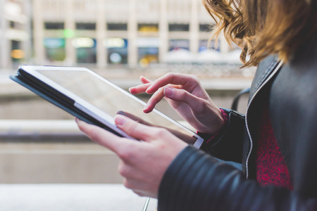 Close up on the hand of young woman using tablet - technology, social network, communication concept