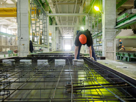Gatchina, Russia - July 23 2019. 
Workers in the workshop of the  House-building plant "Gatchinsky SSK", producing panels for construction and reinforced concrete structures.のeditorial素材