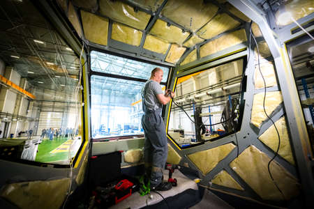 Saint Petersburg, Russia - May 23 2019. 
Plant for the production of electric vehicles "Transport systems". Worker during the assembly of the tram car.のeditorial素材