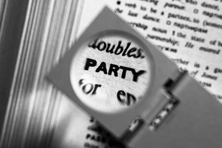 Magnifying glass on the word party in a dictionary.の写真素材