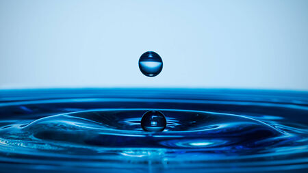 Water splash isolated on blue background.の写真素材