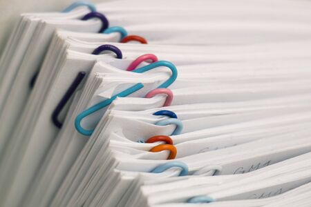 Paper attached by multicolored paper clips.