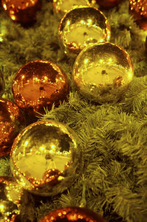 Christmas ornaments lit by treeの写真素材