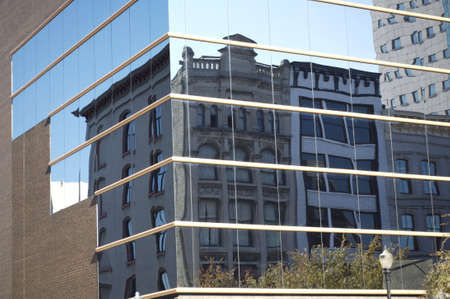Old building row reflected in modern glass buildingの写真素材