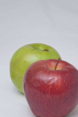 A green and red apple in line on a white backgroundの写真素材