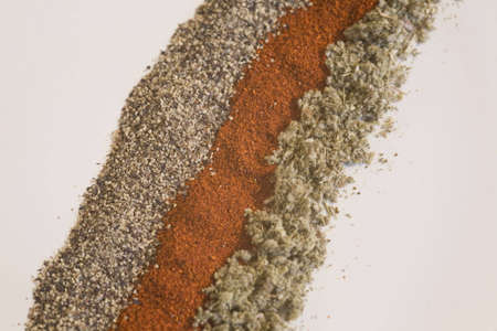 Macro shot of black pepper, paprika, and sage on a white backgroundの写真素材