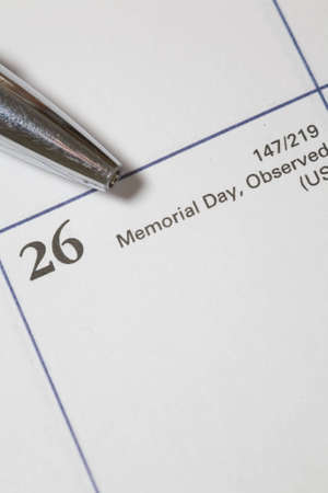 Memorial Day on a calendar with a pencil pointing to itの写真素材