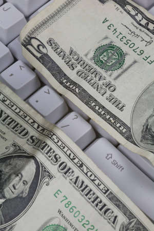 Conceptualization of questioning the US Dollar. Money on a keyboard surrounding the question mark key. の写真素材