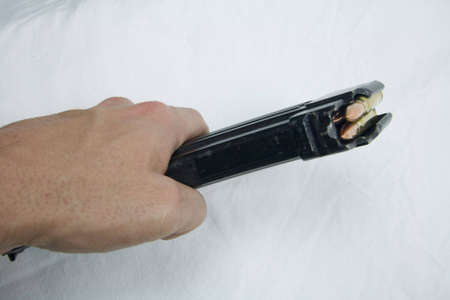 AK-47 magazine being held in a hand. Magazine for favored weapon of insurgents with bulletsの写真素材