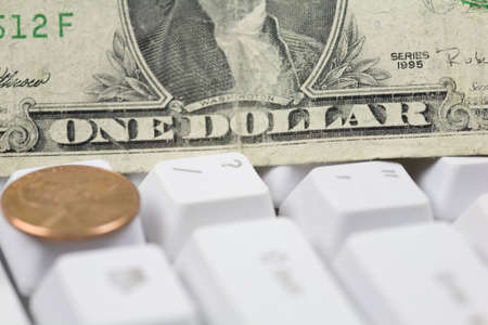 Depiction of questioning falling US currency in the world by backdropping question mark key with a dollar bill and flanking it with a penny.の写真素材