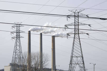 Entire scene filled with items associated with progress; however, no room in the busy skyline for anything else. Smoke stacks, towers, high tension, grid power lines, dominate the scene criss-crossing one another.の写真素材