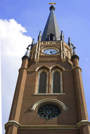 Church tower with cross on top and clock. Reminding parishoners of time to worship with clock on church steeple.の写真素材