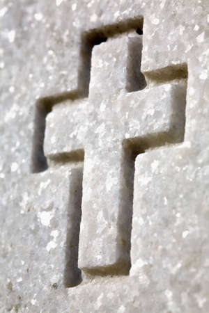 Cross carved into a veteran's headstone. Memorial to fallen soldier carved into granite.