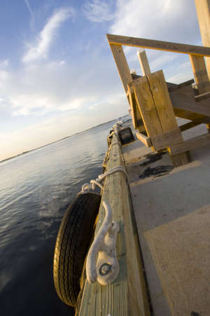 Looking down the length of a dock at a marina in Florida. Port awaiting its boat with bumper, tie downs, and stairs at the readyの写真素材