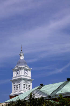 Clock tower on top of a county courthouse. Brick base with white wood town timekeeper.の写真素材