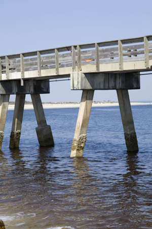 Fishing pier standing in the ocean looking back at the beach. の写真素材