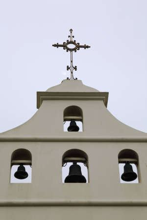 church tower with bells and a cross. Southwestern arch and stucco look.の写真素材