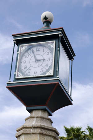 Ornate clock mounted on a concrete post in a public squareの写真素材