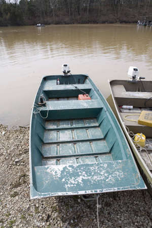 Fishing boats aground at a marina on a rural lakeshoreの写真素材