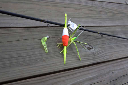 Fishing pole with lures and bobber on a wood の写真素材