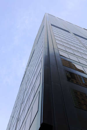 Corner of hise-rise building in shadow. Metal structure dominated by windows. の写真素材