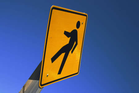 A pedestrian sign mounted on a wooden beam. Conceptualization to beat high fuel costs by walking.の写真素材
