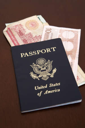 An American passport closeup with a euro and middle eastern dinar currency inside. Symbolization of preparing, saving, or ready for a trip overseas. Holdiay in another country.の写真素材