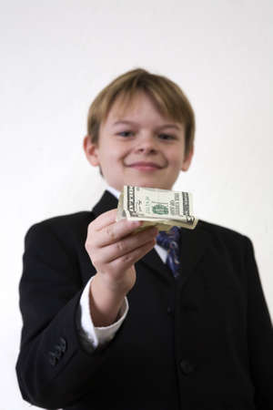 A young man holding out an American 5 dollar bill.  Focus on the money. の写真素材