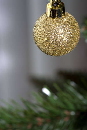 Golden sparkly Christmas ornament hanging from a treeの写真素材