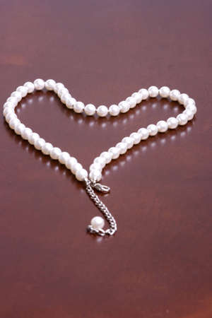 A romantic gift reminder idea of a string of pearls in the shape of a heart. Win your special lady over with pearls on Valentines day.の写真素材